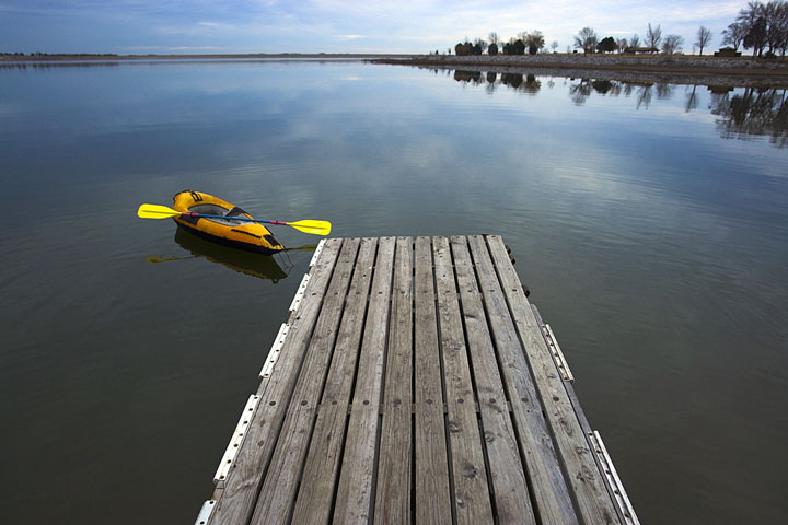 yellow kayak tied to a wooden pier on a Nebraska lake